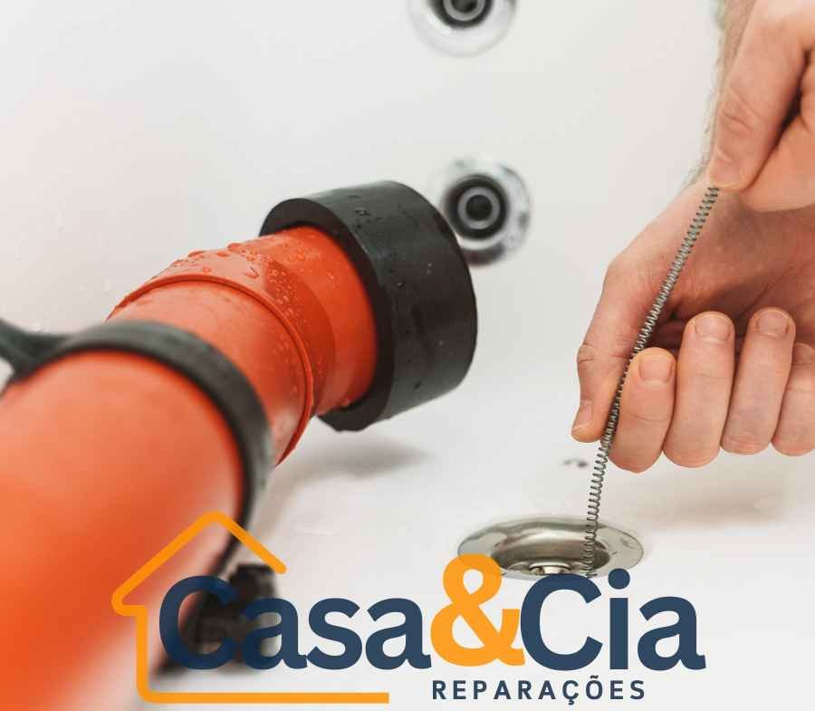 Profissional utilizando ferramenta de desentupimento manual para limpeza de canos