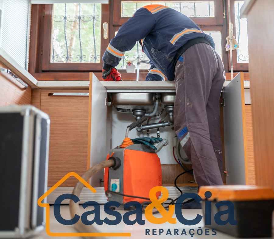 Profissional trabalhando na pia de cozinha com equipamento de desentupimento