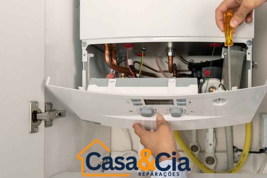 Técnico removendo painel de controle de uma caldeira para manutenção