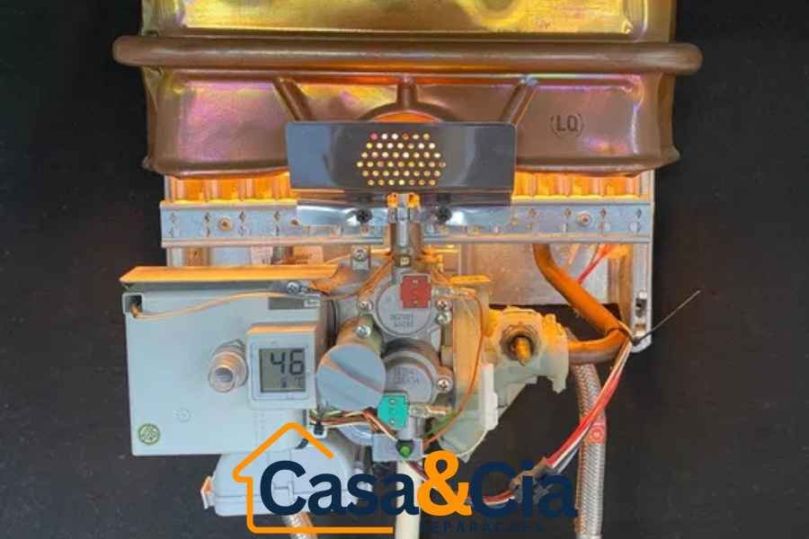 Vista detalhada do sistema interno de um esquentador, destacando circuitos e componentes durante uma reparação de esquentador