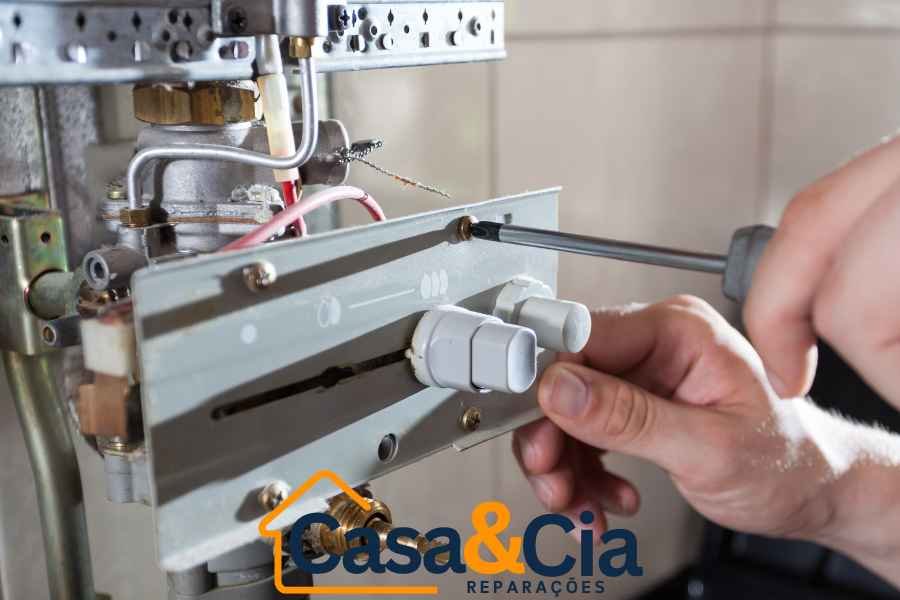 Reparação de esquentador por Técnico da Casa e Cia ajustando componentes internos de um esquentador com uma chave de fenda.