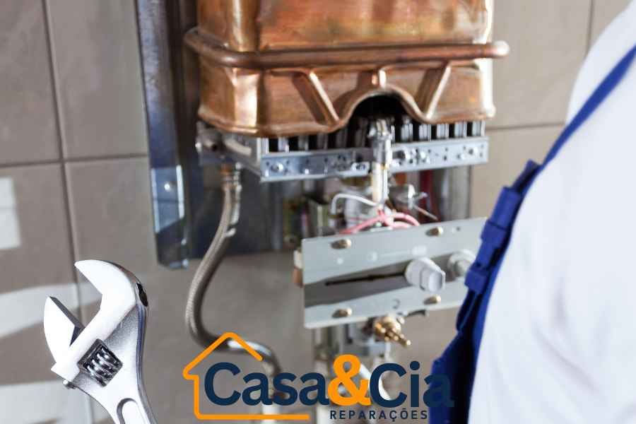 Técnico da Casa e Cia Reparações com uniforme azul realizando uma reparação de esquentadores
