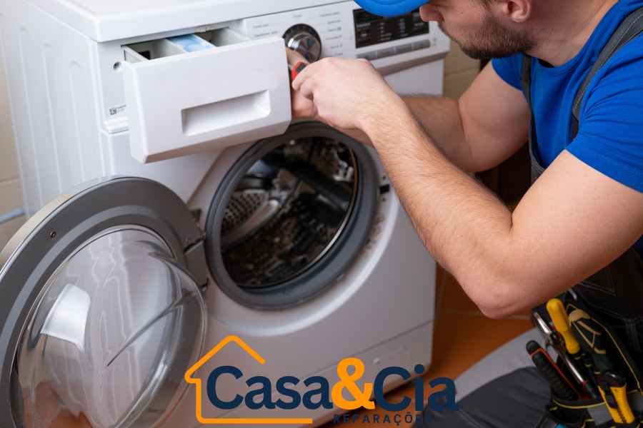 Técnico realizando reparação de máquina de lavar roupa no compartimento de detergente